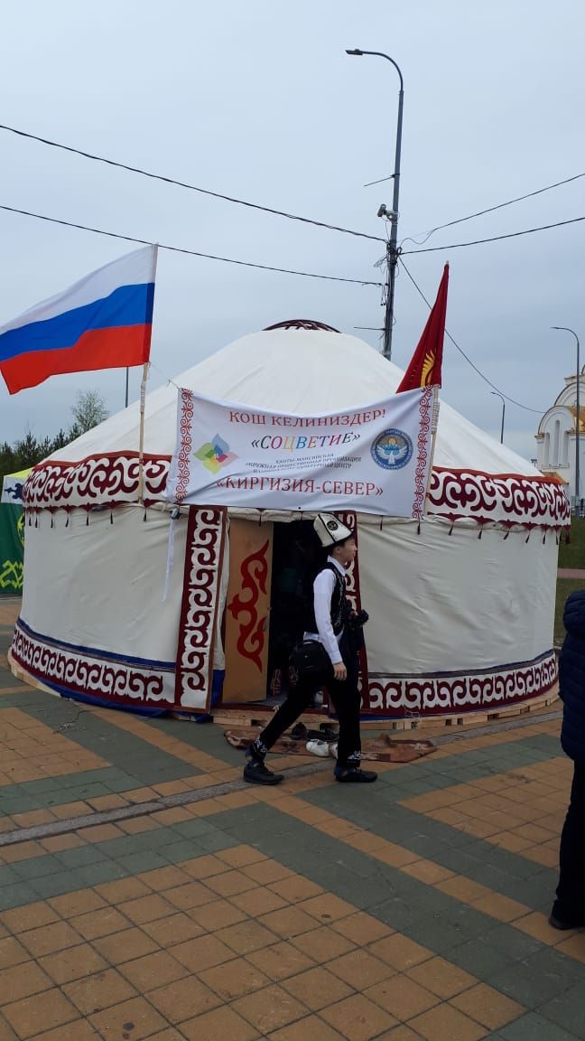 a boy walking near yurt kyrgyz flags